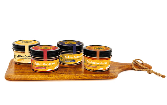 Festive Flight honey gift set with four jars of Louisiana raw and creamed honey on a wooden board